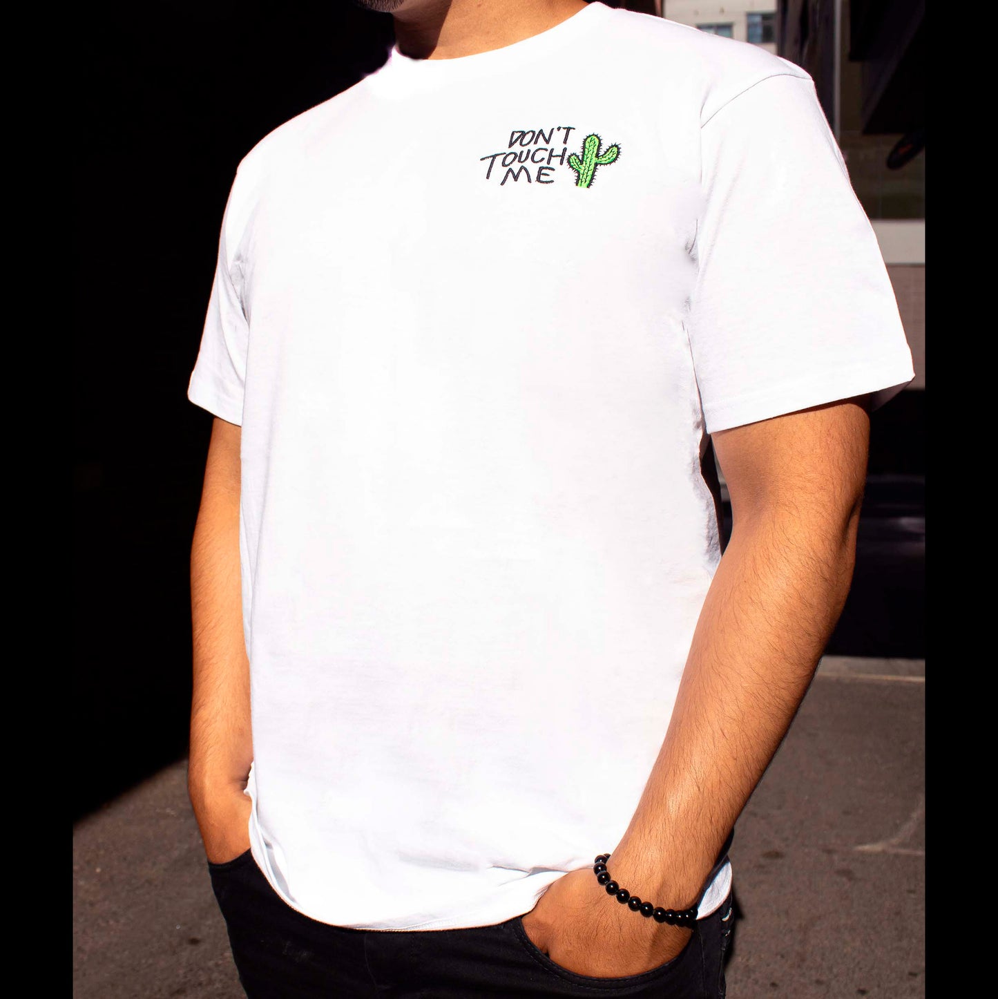 Model wearing a white T shirt with text " Don't touch me" And cactus design.
